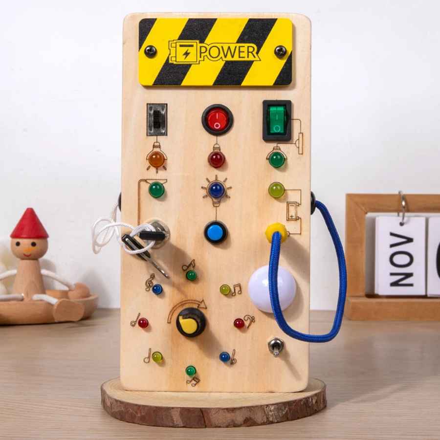 Wooden toy circuit board with buttons and lights on a wooden surface